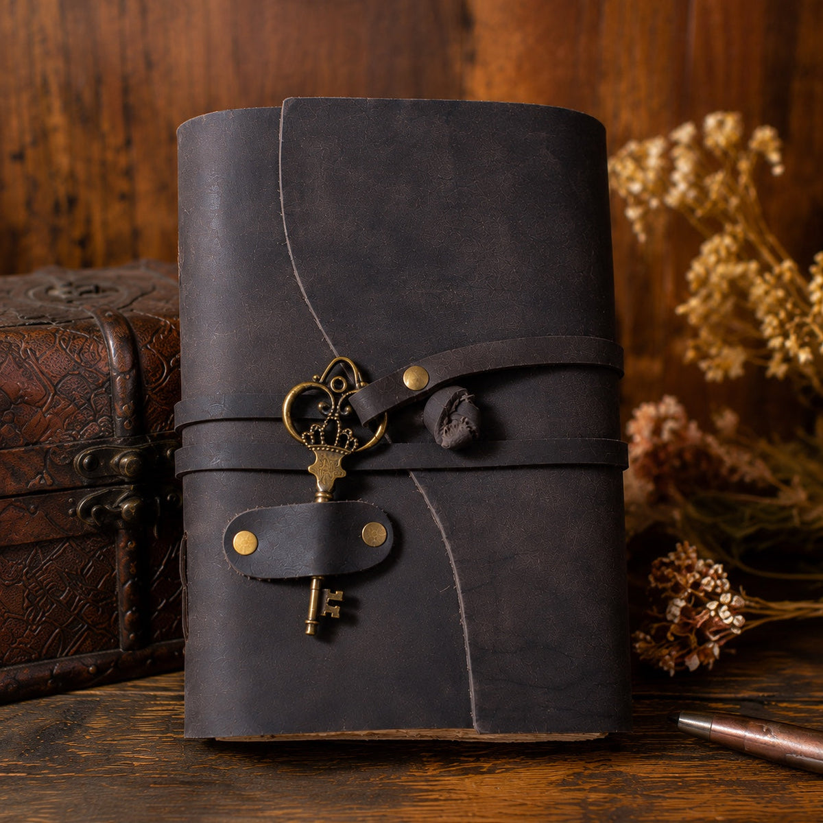 Front view of dark leather journal with brass key charm