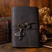 Front view of dark leather journal with brass key charm